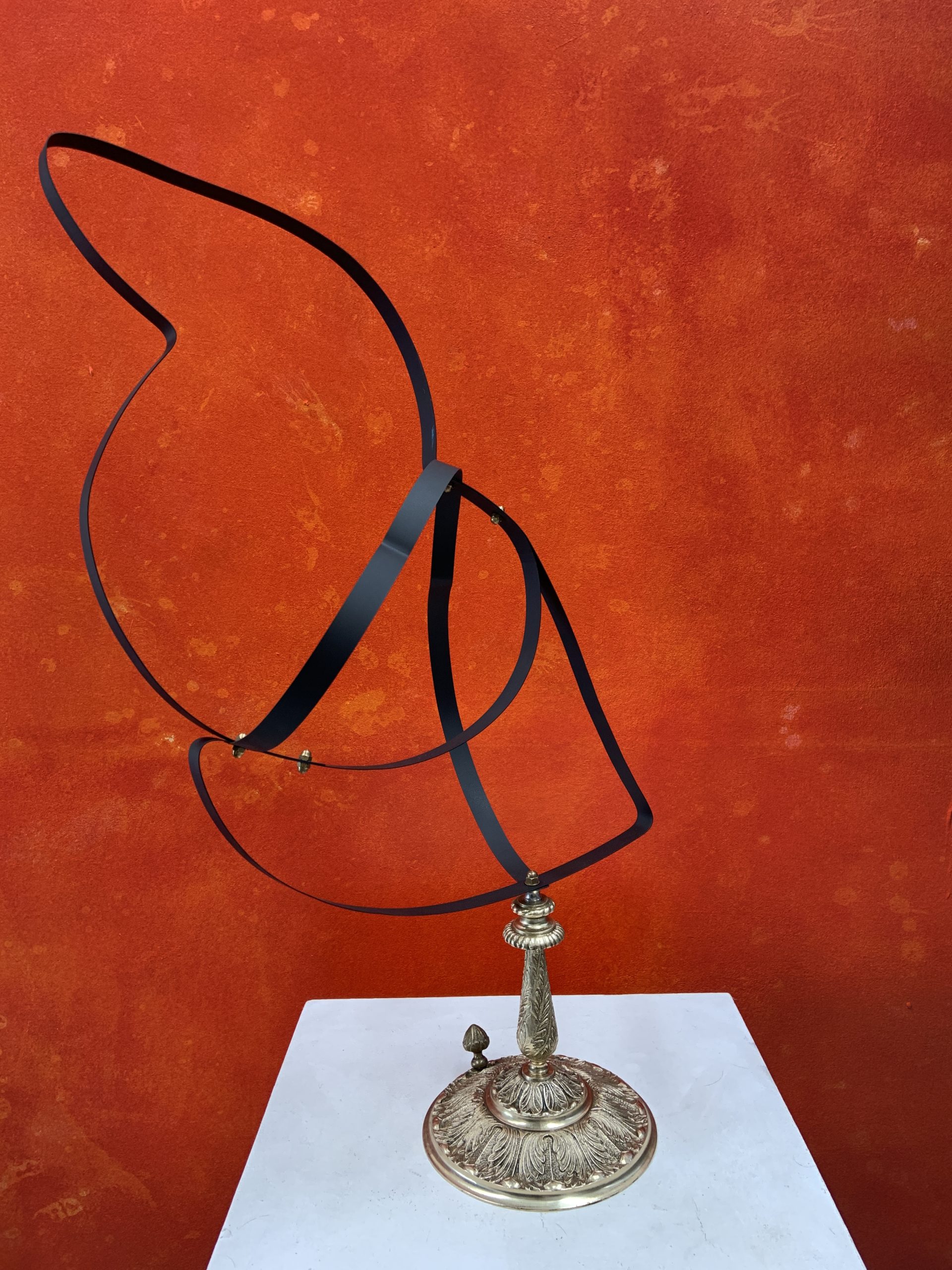 Bird sculpture made from black spring steel strips coiled over a silver-toned base