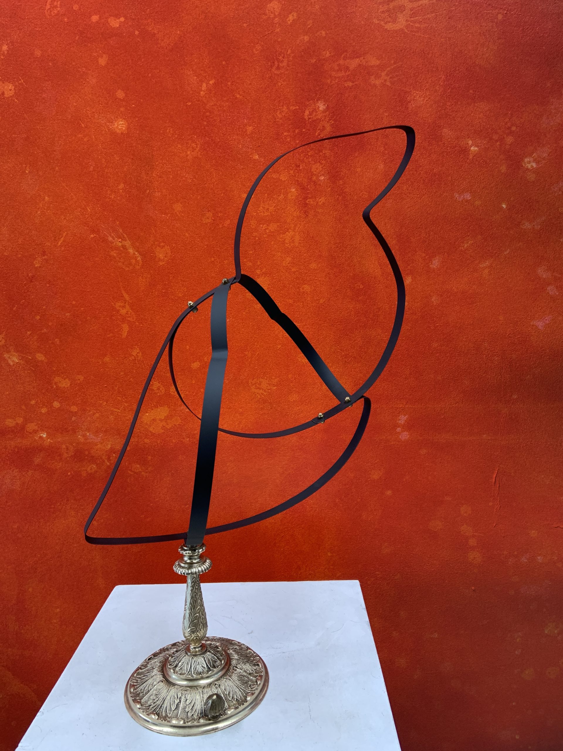 Bird sculpture made from black spring steel strips coiled over a silver-toned base
