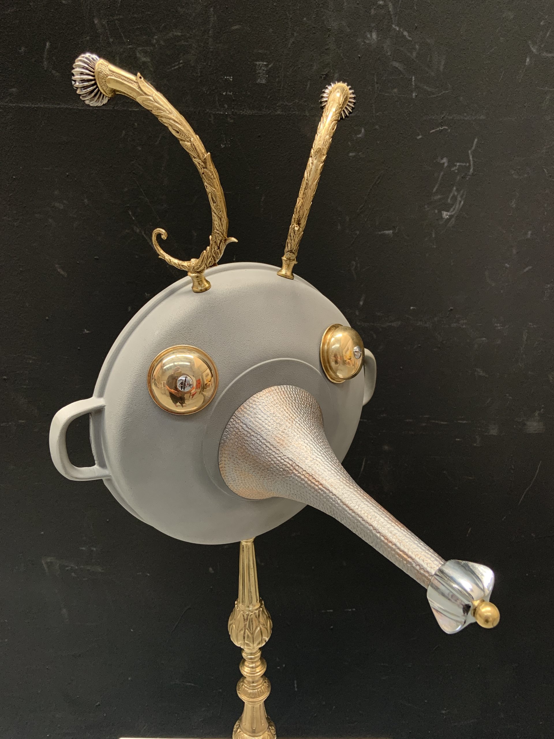 Faun figure made from a saucepan with taps for eyes, on a lamp base - detail