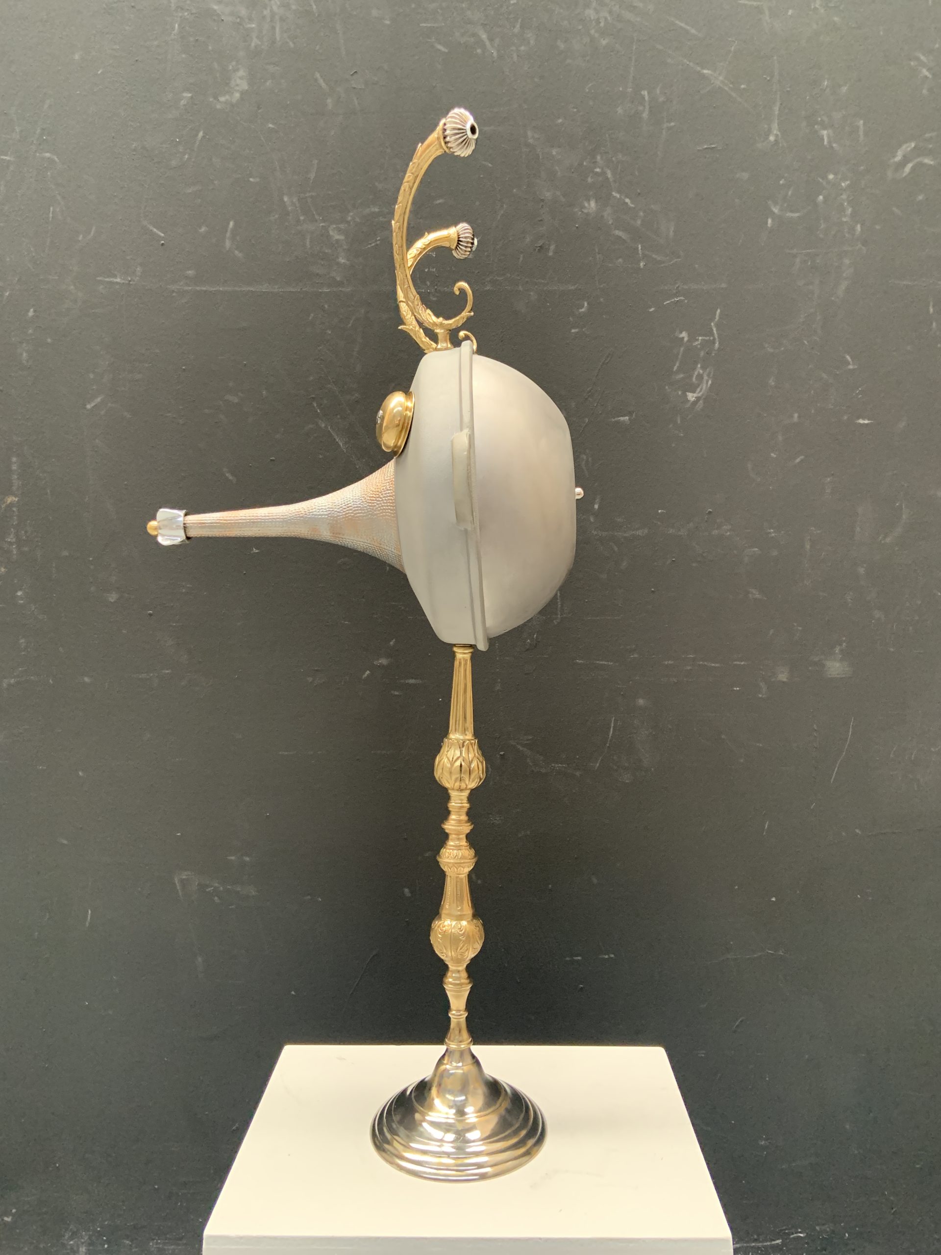 Faun figure made from a saucepan with taps for eyes, on a lamp base - side view
