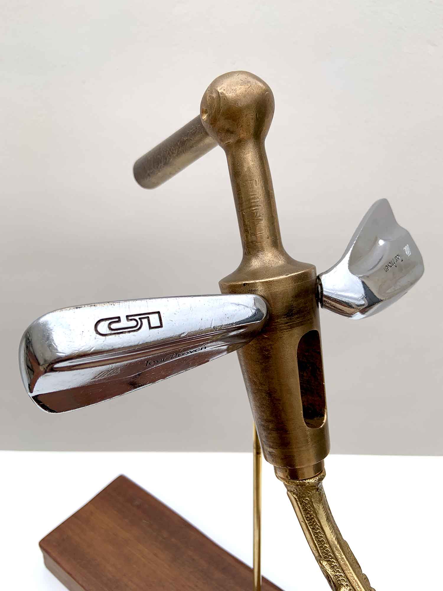 Sculptural bird made from golf club heads mounted on a wooden base – detail