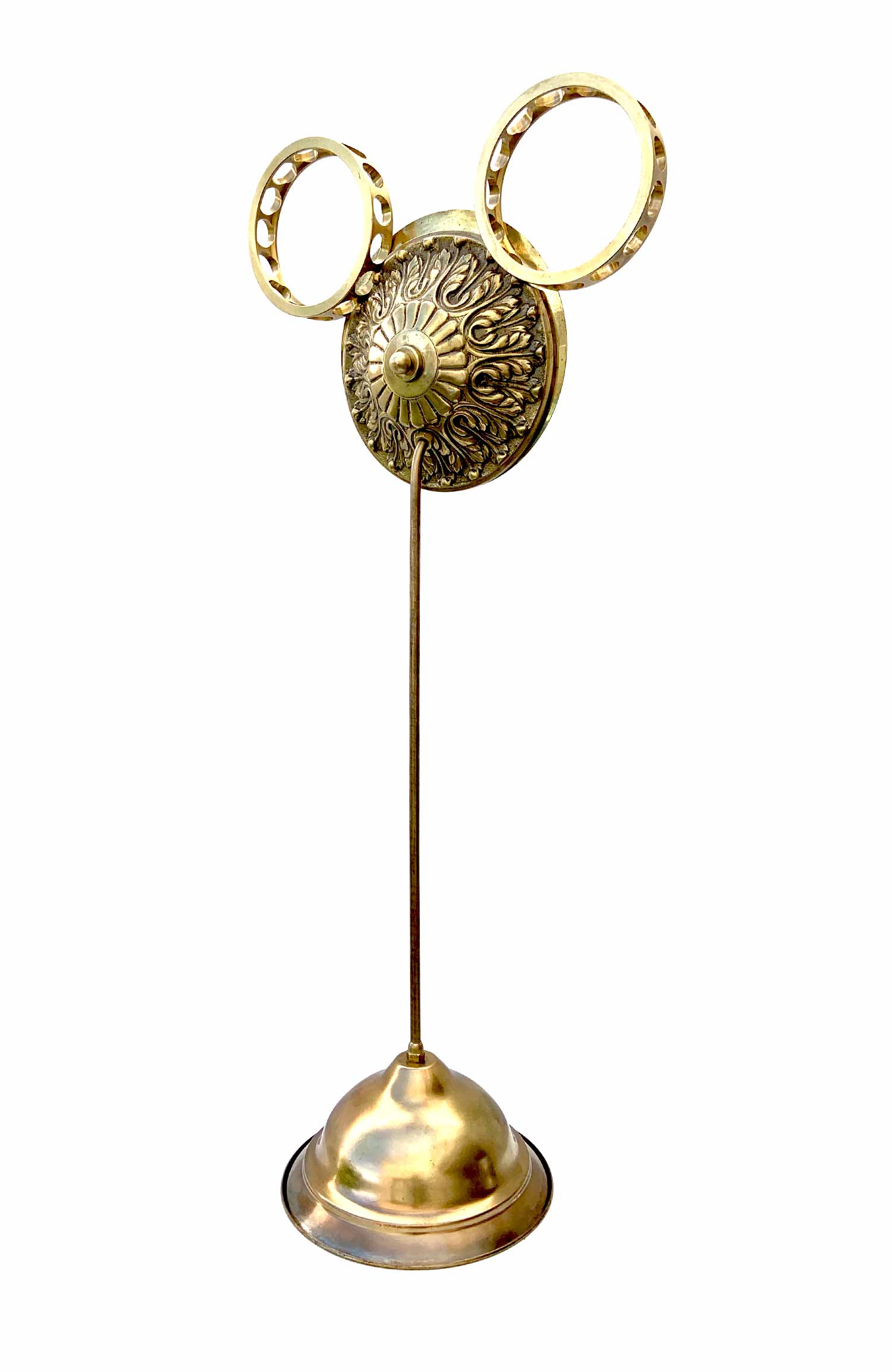 Una escultura con un rostro formado por una esfera con un pomillo a modo de nariz y soportes industriales a modo de orejas; cuenta con una base de la que surge un tallo que sostiene la cabeza.