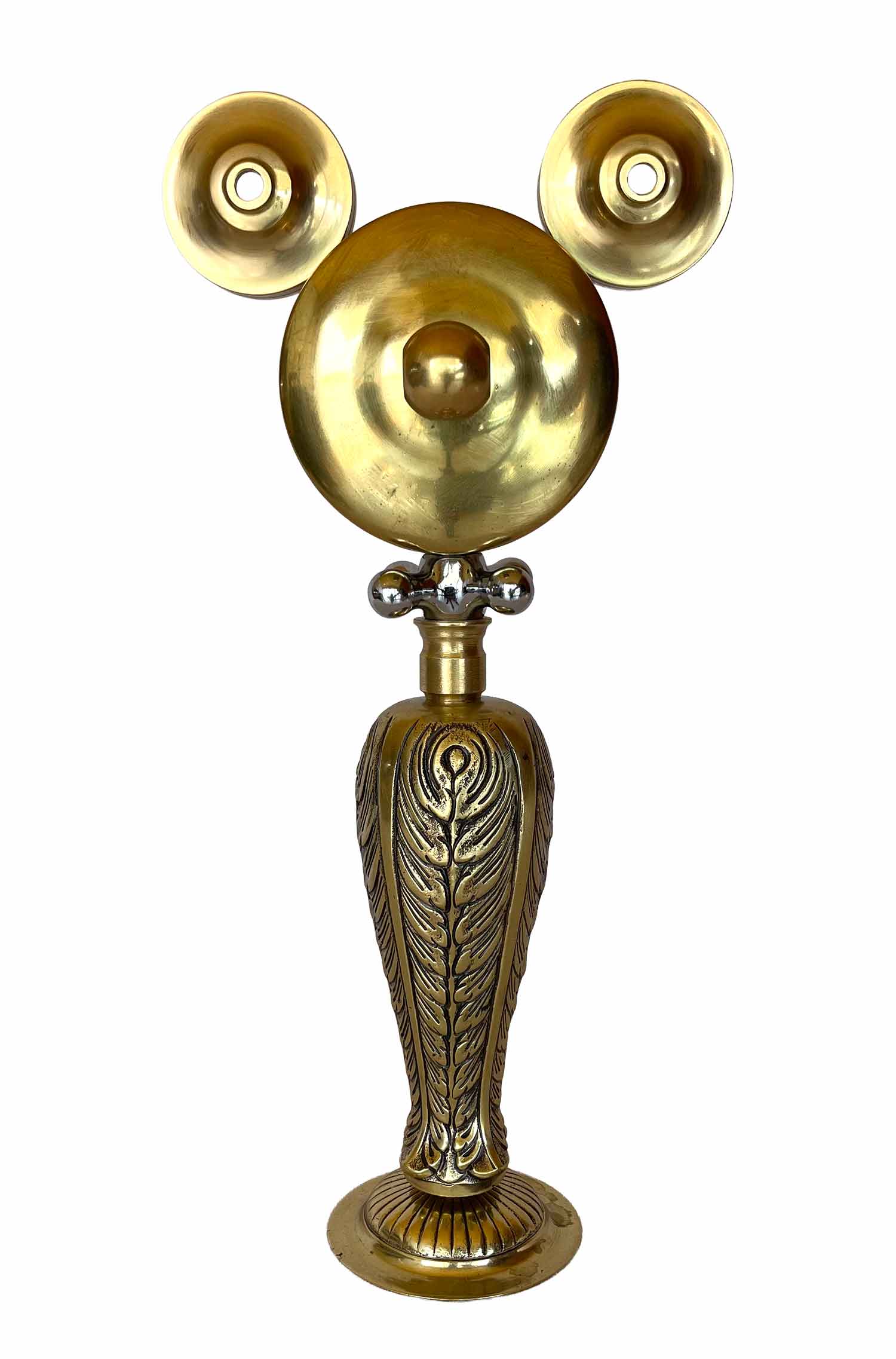Una escultura dorada con el cuerpo y las piernas decorados con motivos ornamentados, y una pieza con forma de maneta que hace las veces de collar.