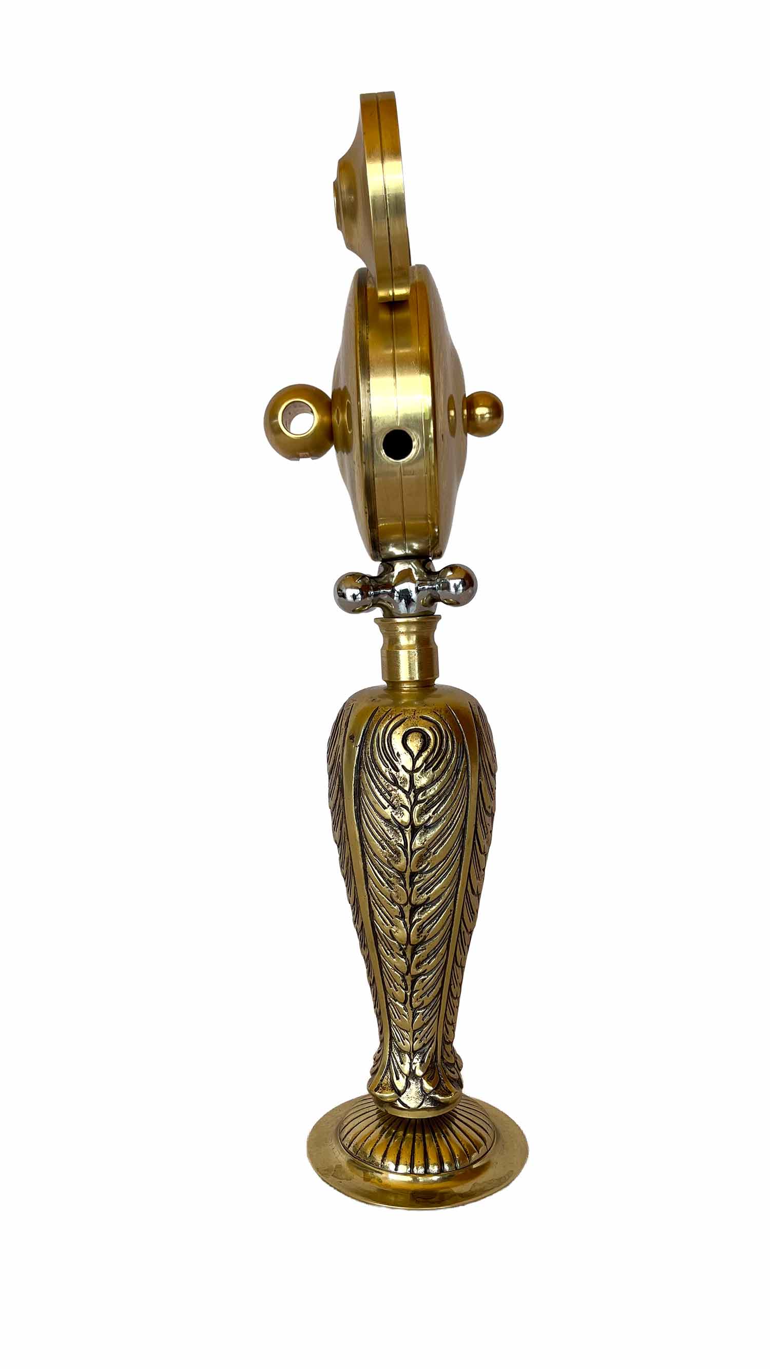 Una escultura dorada con el cuerpo y las piernas decorados con motivos ornamentados, y una pieza con forma de maneta que hace las veces de collar.
