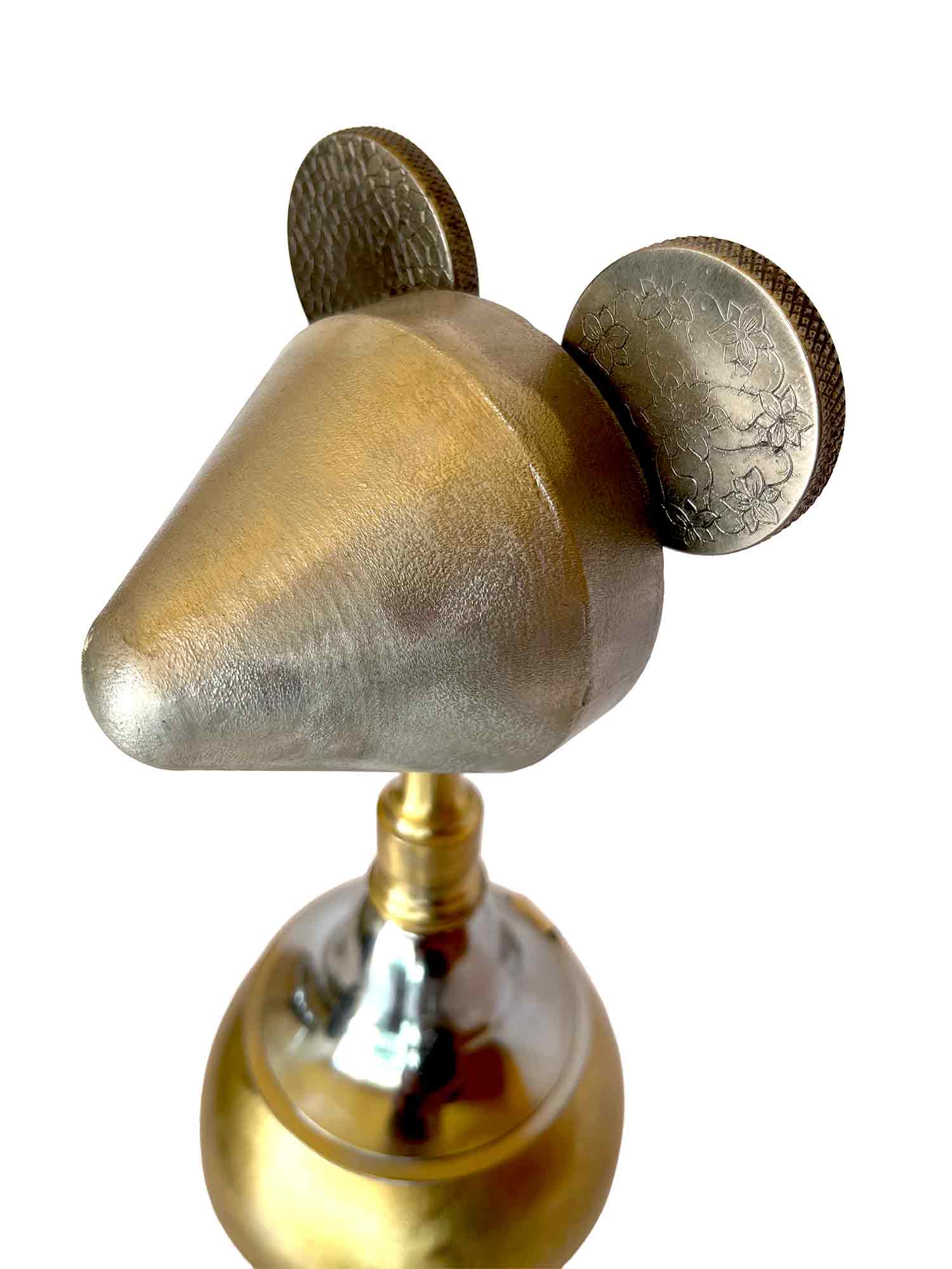 Mickey Mouse hecho con materiales reciclados; la cara es un cono y las orejas son piezas de una máquina de coser; lleva una falda.