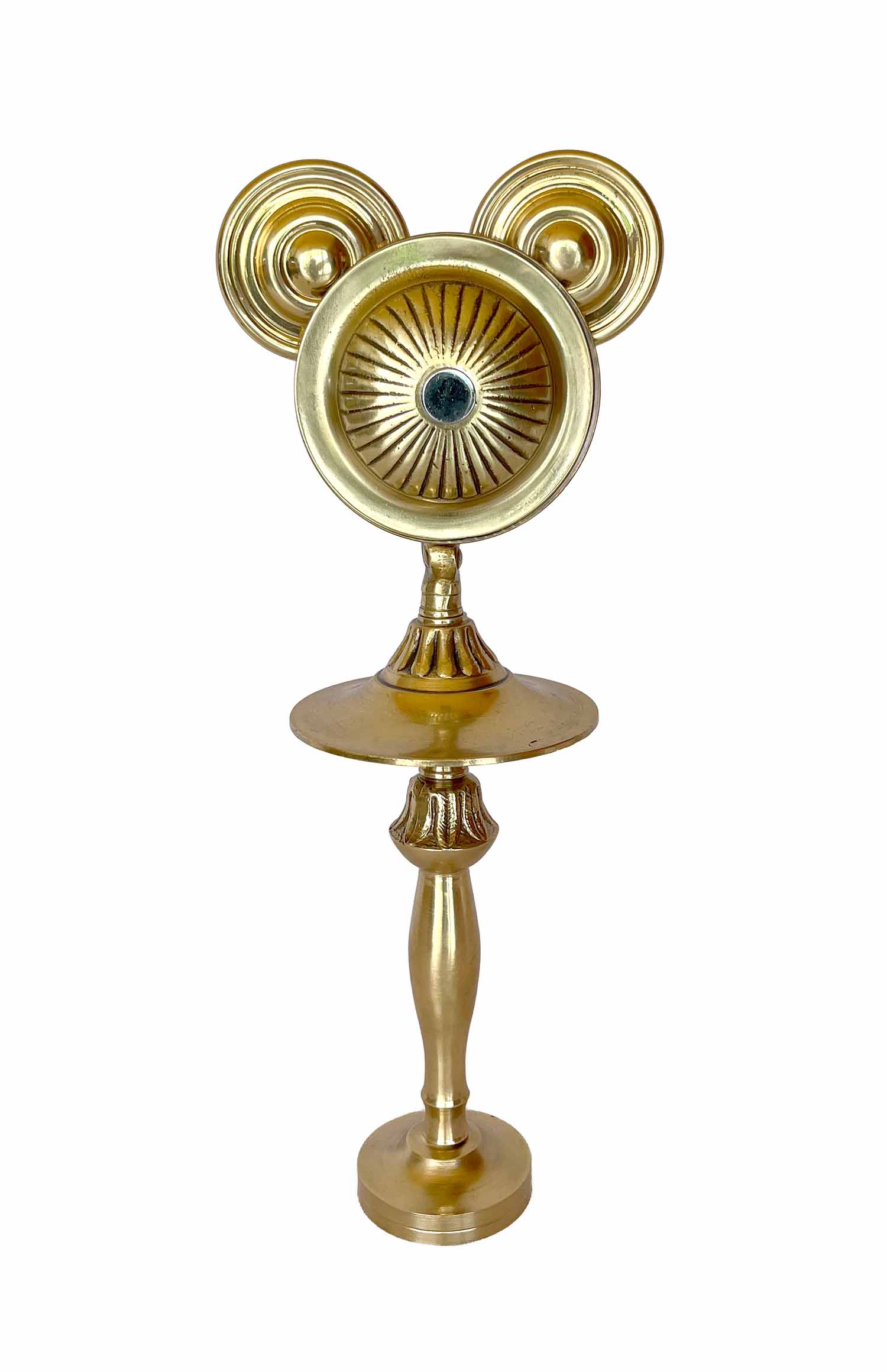 Una escultura dorada con el rostro marcado por rayas que parecen rayos de sol, que lleva una barba postiza y cuyas piernas surgen de un candelabro.