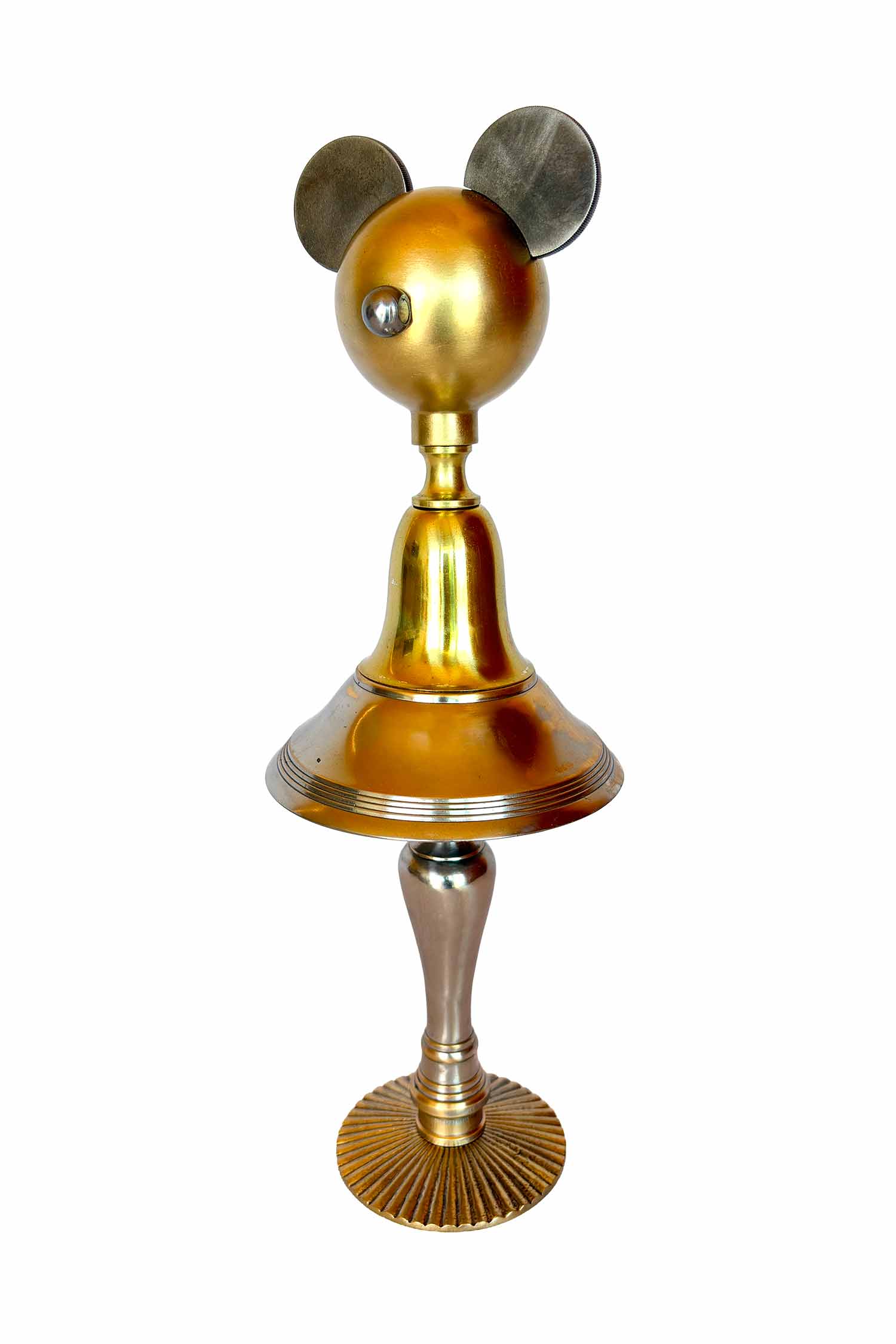 Una escultura dorada compuesta por un pomo a modo de rostro, piezas marinas de Cosir a modo de orejas, un cuerpo y un molde con partes de lámpara, y las patas de un candelabro.