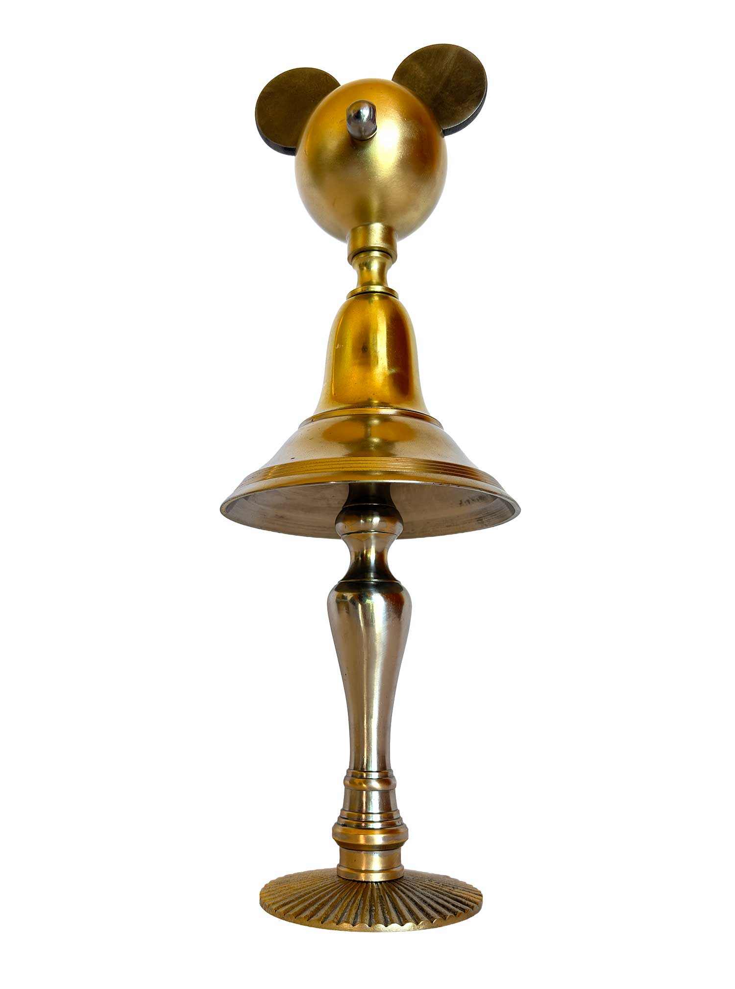 Una escultura dorada compuesta por un pomo a modo de rostro, piezas marinas de Cosir a modo de orejas, un cuerpo y un molde con partes de lámpara, y las patas de un candelabro.